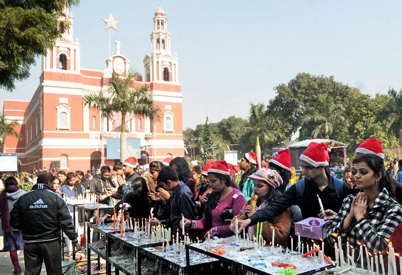 Devotees light candles and pray outside the Sacred Heart Cathedral Church…
