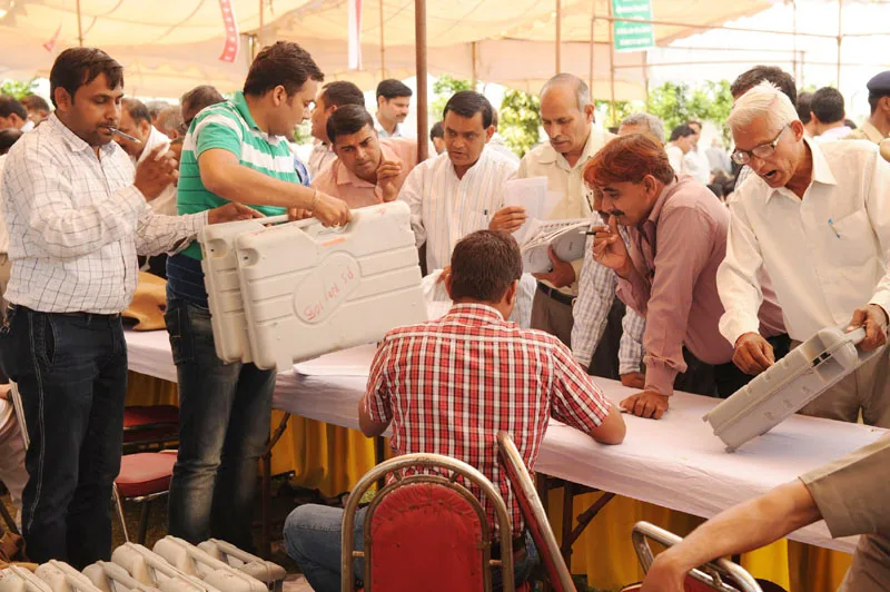 Polling officials at a distribution centre of the Electronic Voting Machines (EVM's) ...