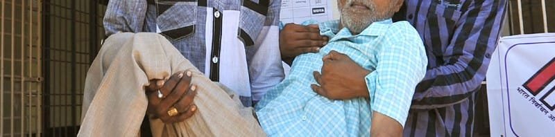 A physically challenged being escorted after casting his vote, at a polling booth,...