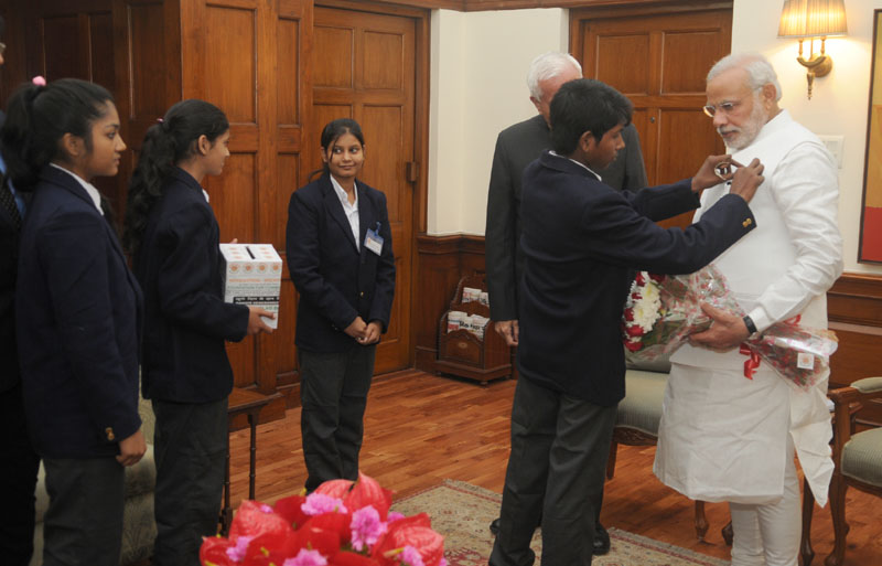 Children supported by National Foundation for Communal Harmony pinning a flag on..